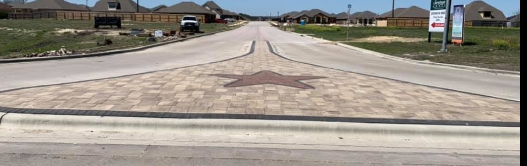 Paver street median with a Texas star inlay running down the centre of a new subdivision road